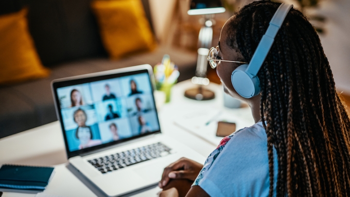 Student with headphones with a laptop on a virtual meeting