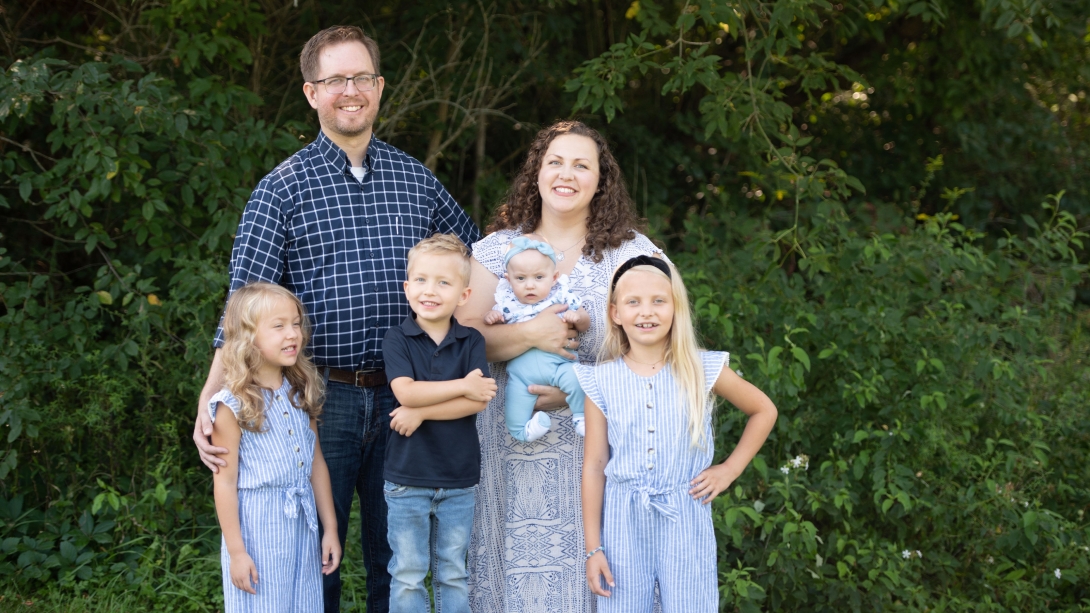 Family smiling in picture trees in background