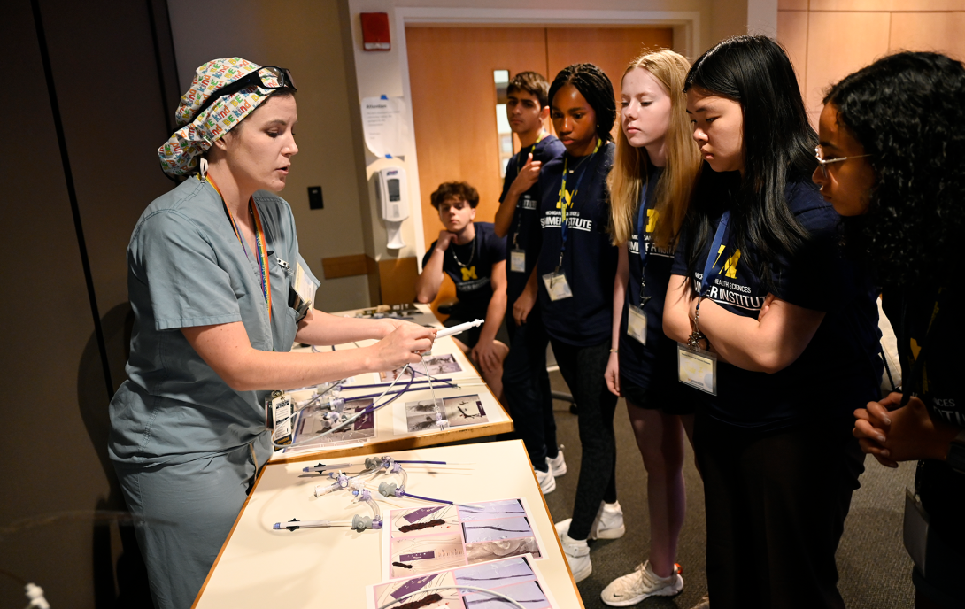 Doctor in scrubs showing students a medical device