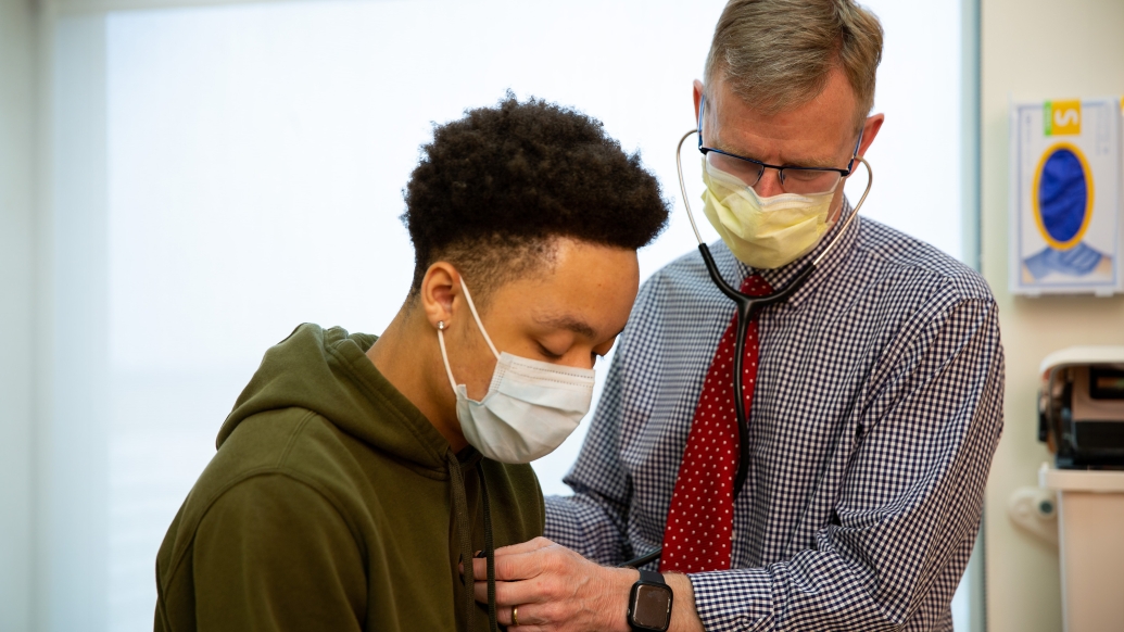 doctor checking heart on patient