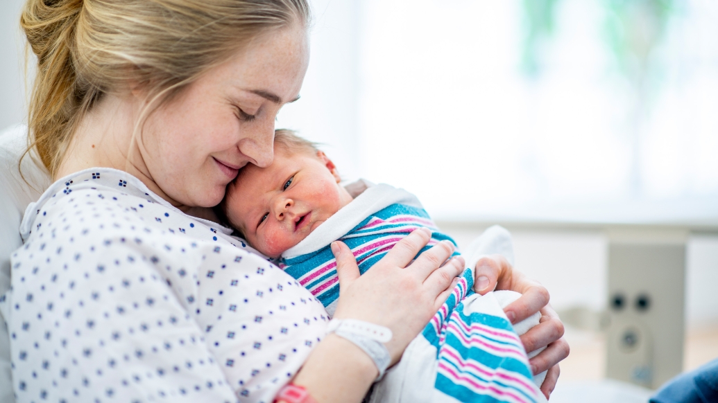 mom in hospital bed holding newborn baby