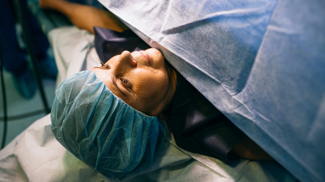 woman laying down and sheet over going into surgery