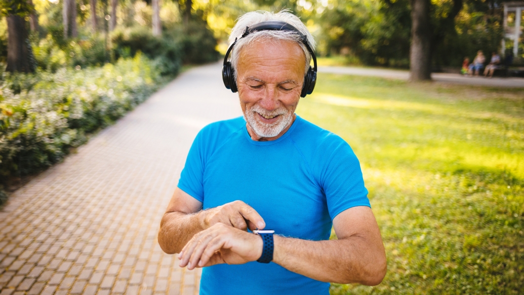 man outside blue shirt headphones watch