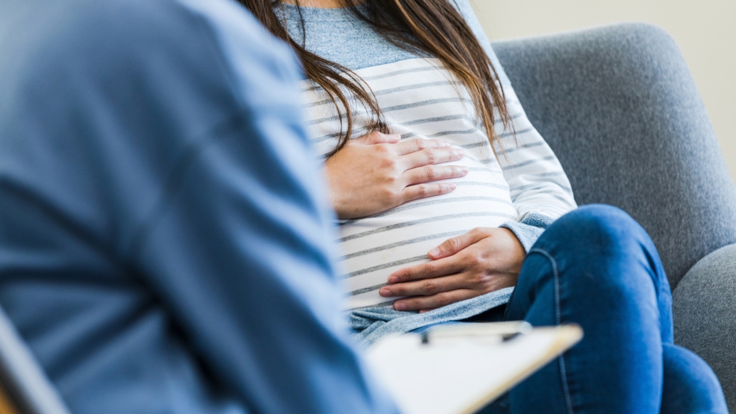 woman holding baby stomach sitting blue and white clothing