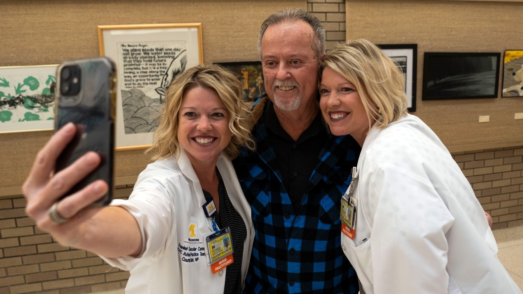 taking a selfie man with two women in white coats