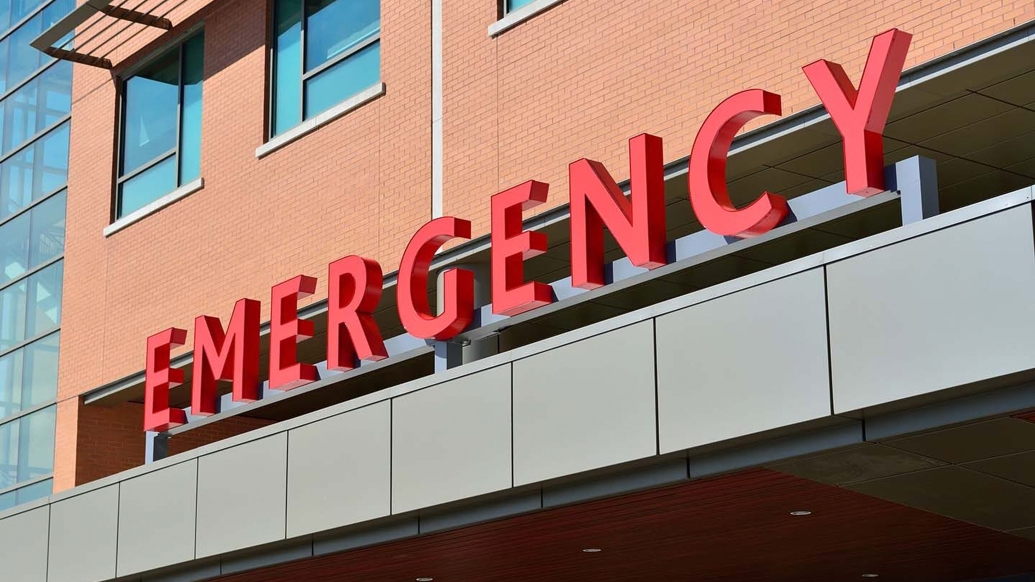 emergency sign wording in red on brick building