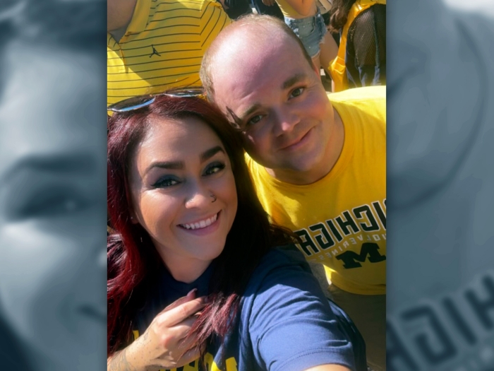 woman smiling with man in michigan gear selfie