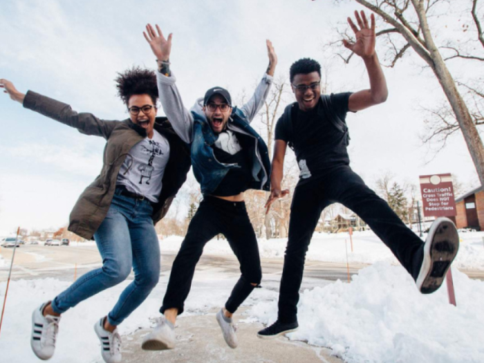 Happy young people jumping in the snow