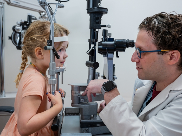 Ophthalmologist Adam Jacobson, M.D., examines a young patient.