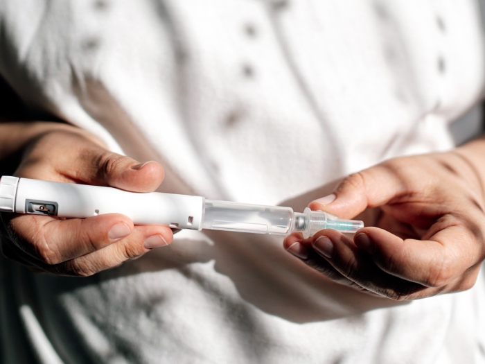 holding syringe white shirt close up in hands