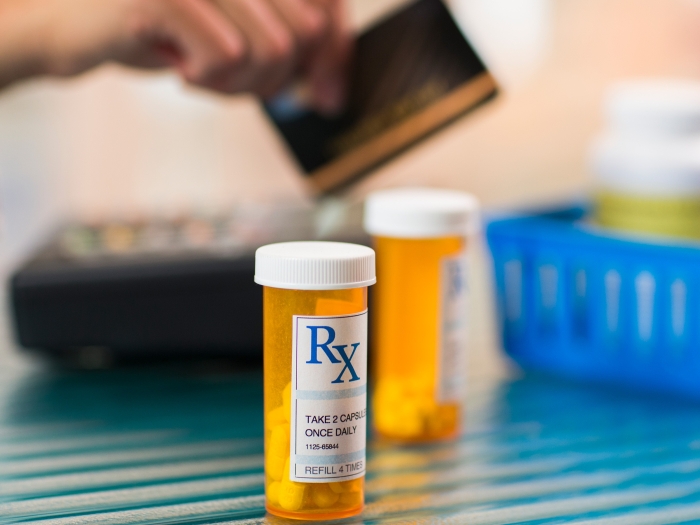 rx bottle orange see through person paying in background