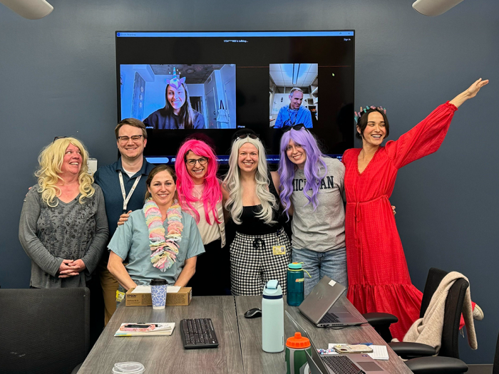 A group of people in a conference room in colorful costumes