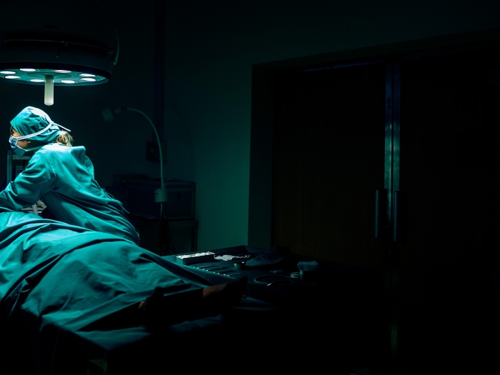 surgeon dark room over surgery patient on hospital table