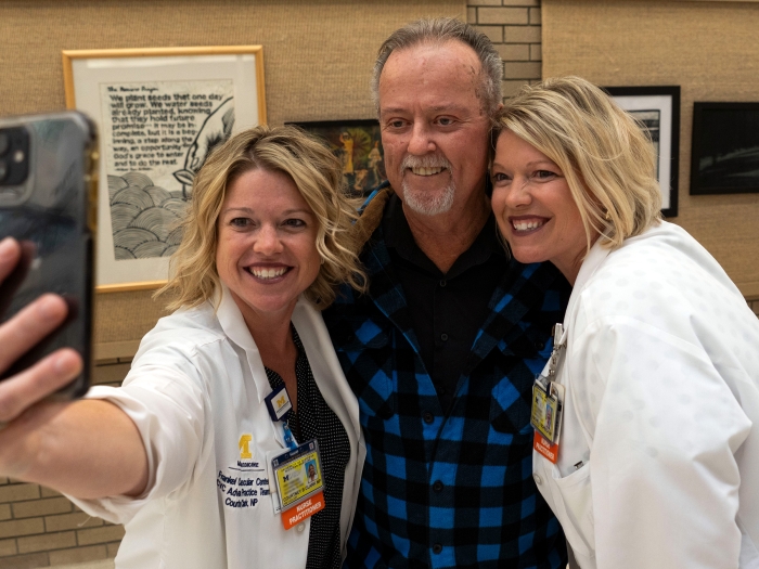 taking a selfie man with two women in white coats