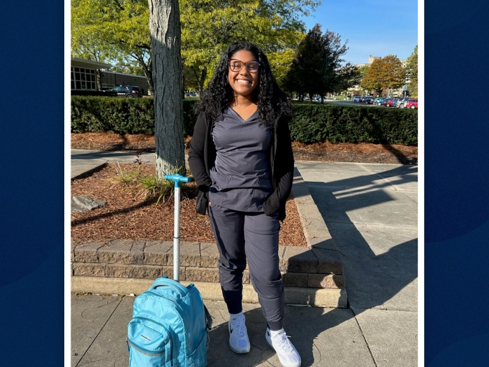 young woman standing on her own smiling outside