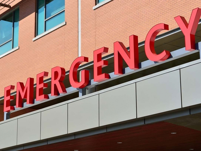 emergency sign wording in red on brick building