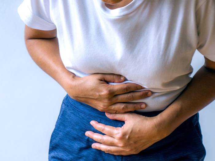 woman leaning over holding stomach