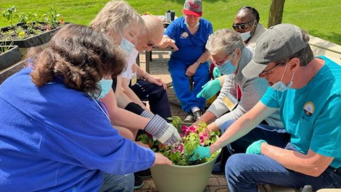 Silver Club members work on a planter in the garden group