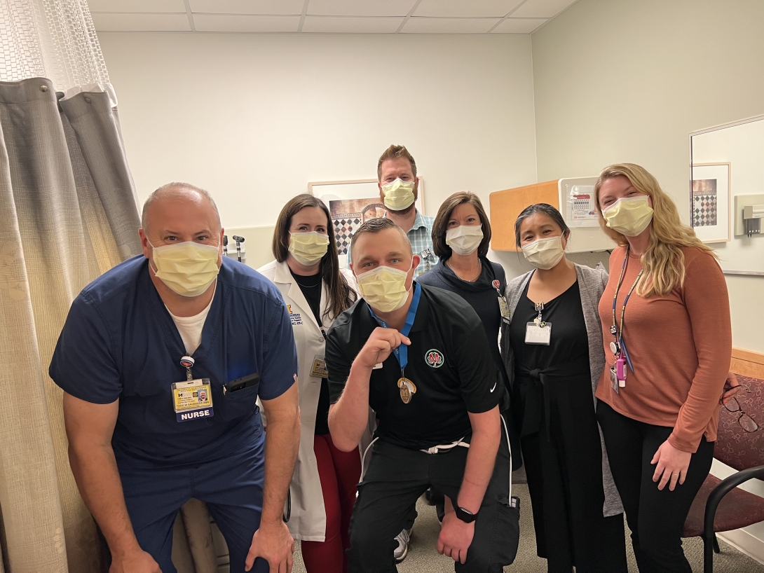 Staff standing in patient area with masks on near curtain