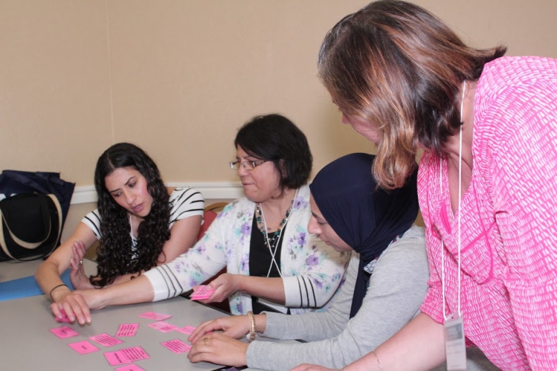 Attendees sit at small table for training using post-its